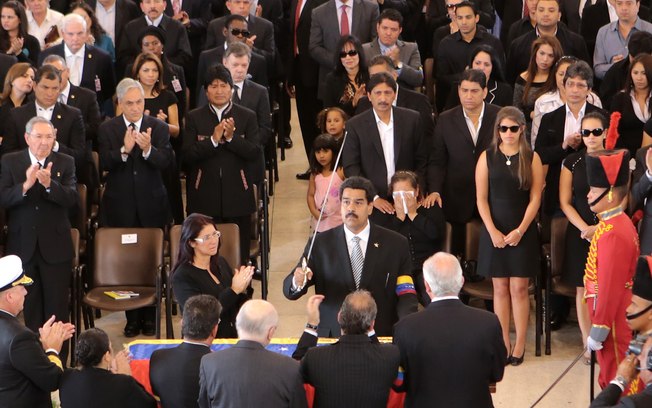 Foto divulgada pelo Palácio de Miraflores mostra vice-presidente Nicolás Maduro com réplica de espada de Simon Bolívar perto de caixão de Hugo Chávez (Foto: AP)