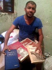 Cícero Pereira Batista mostra livros achados no lixo e com os quais  estudou para virar médico (Foto: Raquel Morais/G1)