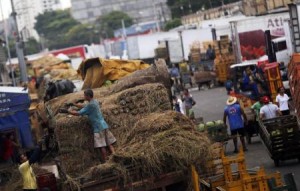 Trabalhadores descarregam alimentos de caminhões no Ceagesp, em São Paulo