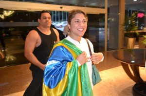 Bethe Correia chega ao hotel sorridente e com bandeira do Brasil  (Foto: Raphael Marinho)