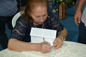 Pastora Isa Matos autografando o livro no lançamento (Foto: Iguaí Mix)